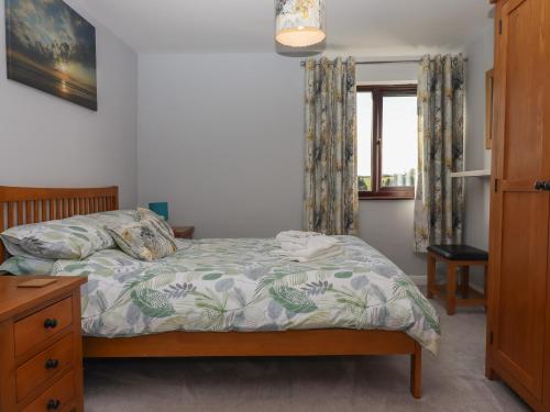 - une chambre avec un lit et une fenêtre dans l'établissement Dairy Cottage, à South Molton