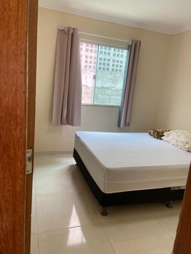 a bedroom with a bed and a window at Casa Village do Sol in Guarapari