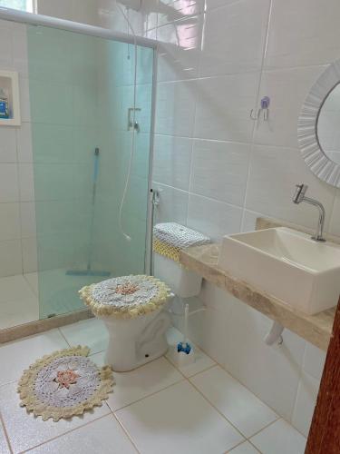 a bathroom with a shower and a toilet and a sink at Casa Village do Sol in Guarapari