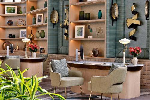 a lobby with a desk and chairs and vases at Waldorf Astoria Cairo Heliopolis in Cairo