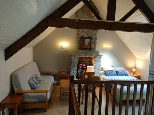 Cette chambre mansardée comprend un lit et un mur en pierre. dans l'établissement Gîtes de Keravy Vannes, à Vannes