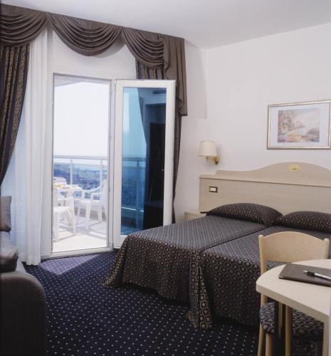 a hotel room with a bed and a balcony at Hotel Caravelle&MiniCaravelle in Lido di Jesolo