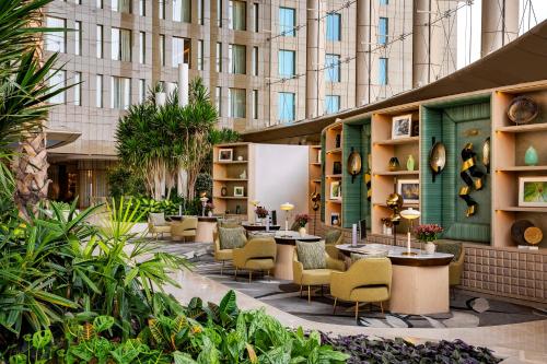a courtyard with chairs and tables and a building at Waldorf Astoria Cairo Heliopolis in Cairo