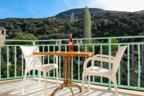 a table with two chairs and wine glasses on a balcony at Rezidenca Panorama Apartments in Vlorë