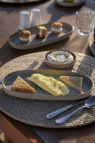 einen Tisch mit Käseplatten und Brot darauf in der Unterkunft The Zen Wellness Resort in Assuan
