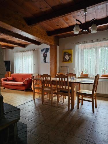 Villa Pandora - Zakopane Centrum في زاكوباني: غرفة معيشة مع طاولة وكراسي وأريكة