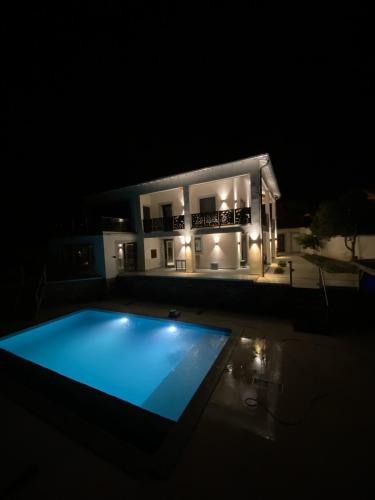 une piscine devant une maison la nuit dans l'établissement LE LOFT AUX MIMOSAS - BORMES LES MIMOSAS - PISCINE, à Bormes-les-Mimosas