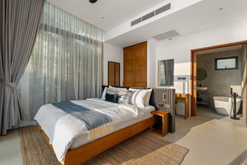 a bedroom with a large bed and a bathroom at Kove Samui in Koh Samui 