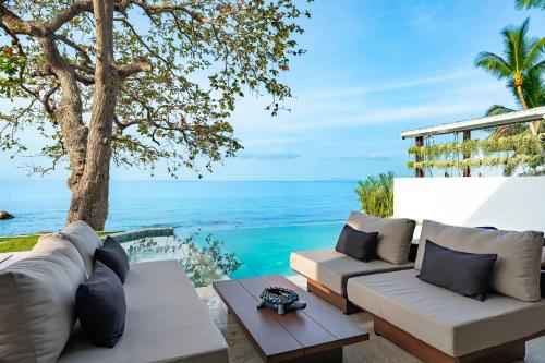 a patio with a view of the ocean at Kove Samui - Absolute Beachfront Villas in Koh Samui 