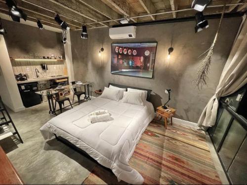 a bedroom with a large white bed and a table at Vem pro Copan in Sao Paulo
