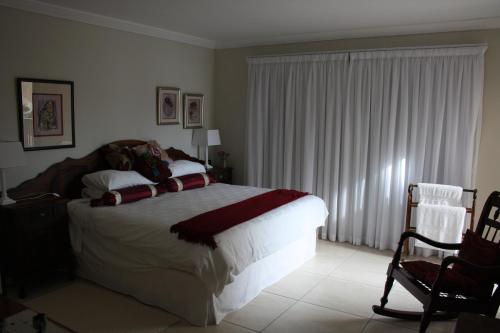 a bedroom with a large bed and a chair at Beachcastle in Stilbaai
