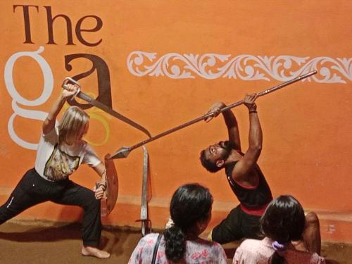 a group of people watching a woman performing a performance at View Valley Homestay in Munnar