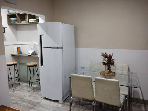 a kitchen with a table and a white refrigerator at Hospedaje La Bussola I in Gualeguaychú