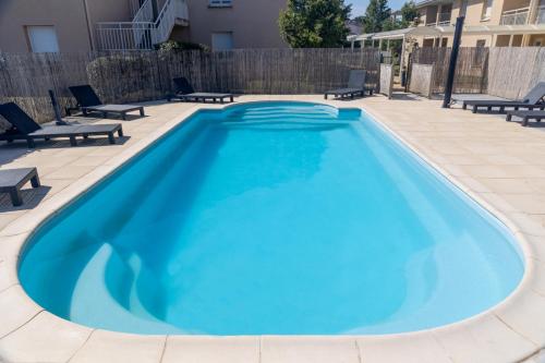 einen Pool mit blauem Wasser auf einer Terrasse in der Unterkunft Patio Parc Résidence in Argenton lʼÉglise