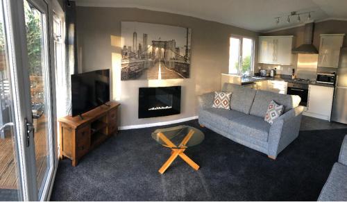a living room with a couch and a fireplace at Peaceful Holiday Lodge with Hot Tub in Lincolnshire