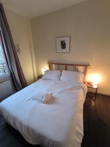 sypialnia z dużym białym łóżkiem z 2 poduszkami w obiekcie B Appartement w mieście Malakoff