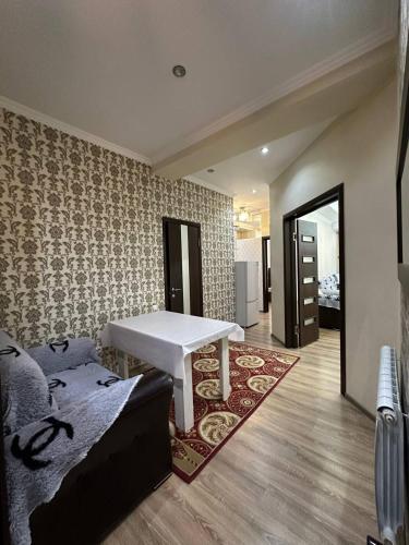 een woonkamer met een witte tafel en een tapijt bij apartment on st. Frunze 553 in Bisjkek