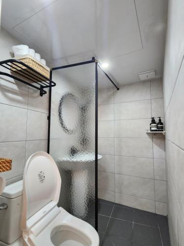 uma casa de banho com um WC e uma cabina de duche em vidro. em And spring em Jeonju