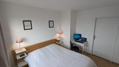 a bedroom with a bed and a desk with a computer at Paris'door Cozy 2P 50m² all equipped in a village in Le Pré-Saint-Gervais