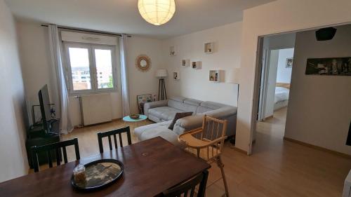 a living room with a couch and a table at Paris'door Cozy 2P 50m² all equipped in a village in Le Pré-Saint-Gervais