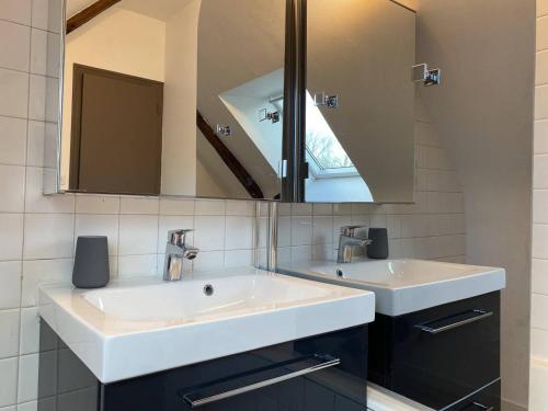 uma casa de banho com 2 lavatórios e um espelho em 903 - Magnifique longère entièrement rénovée quelques kilomètres des plages d'Erquy em Erquy