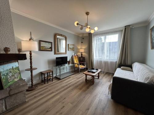 un salon avec un canapé et une télévision dans l'établissement 801 - Maison 4 couchages, à deux pas du centre d'Erquy, à Erquy