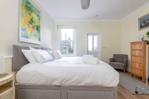 een slaapkamer met een groot wit bed en een stoel bij 44 Argyle Street - 2 Bed-1 Bath - Central in St Andrews