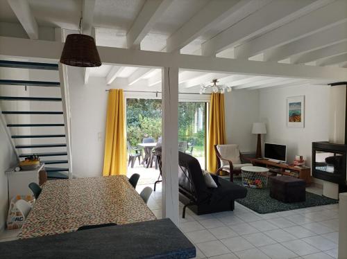 un salon avec une table et une salle à manger dans l'établissement 761 - Maison individuelle, dans une résidence privée avec piscine, disposant d'un jardin plein sud sans vis-à-vis, à Erquy