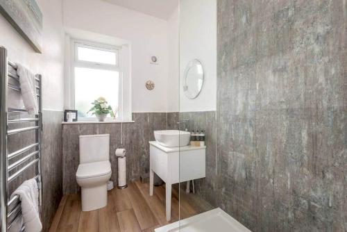 een badkamer met een toilet, een wastafel en een raam bij 44 Argyle Street - 2 Bed-1 Bath - Central in St Andrews