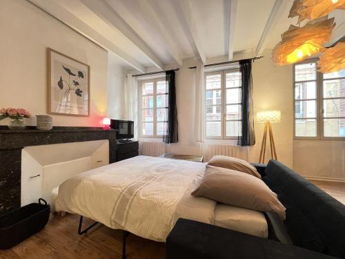 ein Schlafzimmer mit einem großen Bett und einem Sofa in der Unterkunft Le Vogue - 4-6p - hypercentre-metro in Toulouse
