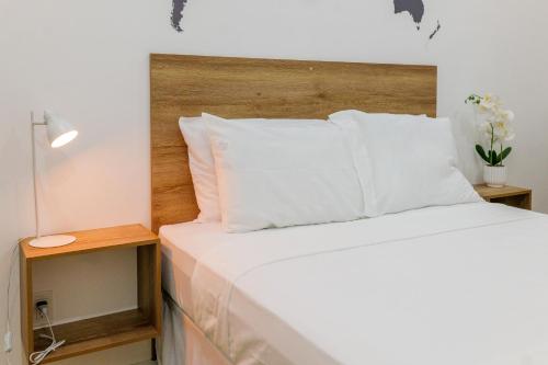 łóżko z białymi poduszkami i drewnianym zagłówkiem w obiekcie Casa valencia 3 w mieście Santa Elena