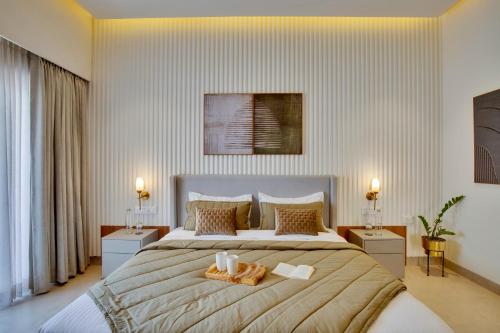 a bedroom with a large bed with two candles on it at ELIVAAS Shourya Bliss Lux 3BHK Villa with Pvt Pool, Udaipur in Udaipur