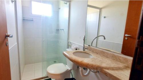 a bathroom with a sink and a shower and a toilet at Descanse perto da praia in Porto Seguro