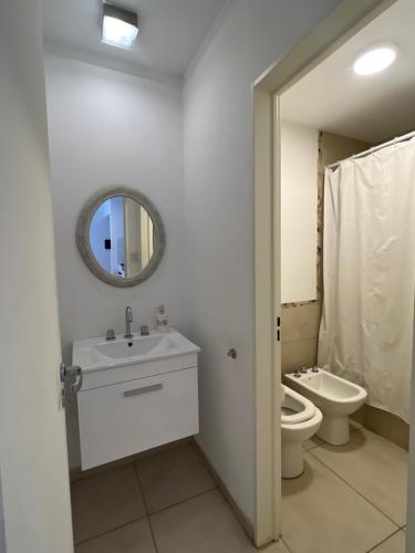 uma casa de banho com um lavatório, um WC e um espelho. em Departamento amoblado 1 dormitorio Familiar em Bahía Blanca