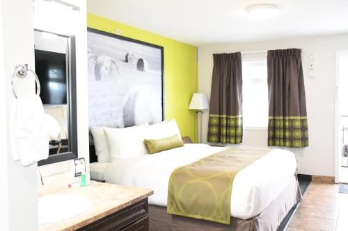 a hotel room with a bed and a sink at Super 8 by Wyndham Fort McMurray in Fort McMurray
