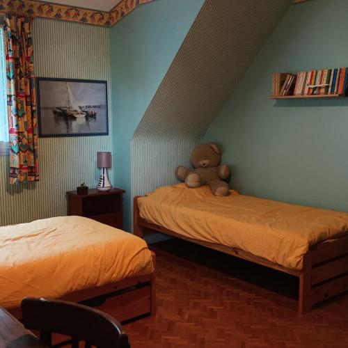 - une chambre avec 2 lits et un ours en peluche à l'angle dans l'établissement Ty Sklaer, à 200 m de la mer, à Penvénan