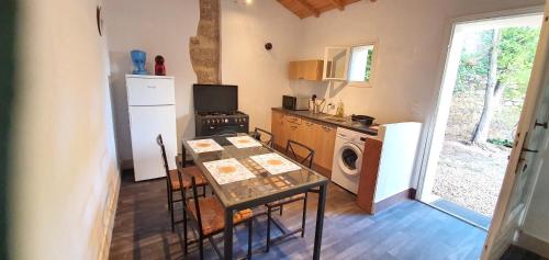 Il comprend une cuisine équipée d'une table, d'une cuisinière et d'un four micro-ondes. dans l'établissement Maison charmante à Narbonne avec piscine et jardin, à Narbonne