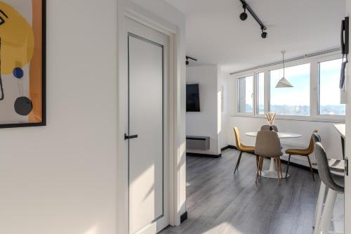 a dining room with a table and chairs and a room with windows at 77 views apartments by INSHI in Lviv
