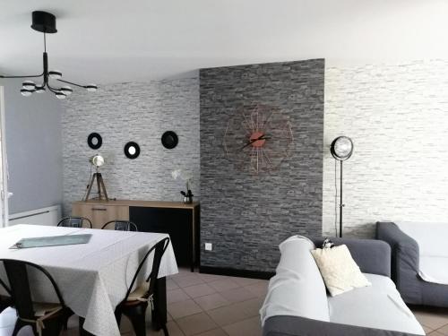 un salon avec un canapé et une horloge au mur dans l'établissement Au fil de la lys, à Merville