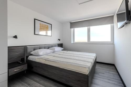 a bedroom with a bed and a window at 77 views apartments by INSHI in Lviv
