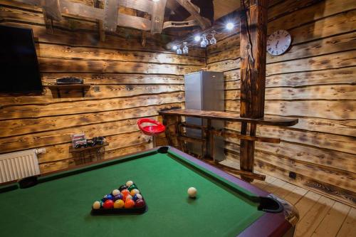 a billiard room with a pool table in a cabin at Domek całoroczny RYSIÓWKA na Kaszubach z basenem banią sauną bilardem na wyłączność - Ostrowite Leśna Dolina in Sulęczyno