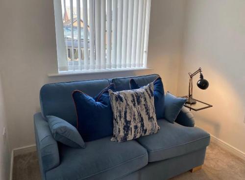 a blue couch in a living room with a window at Temper Mill 3 BR Garden & FREE parking in Newport