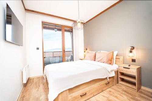 een slaapkamer met een bed en een groot raam bij Bansko Best View Apartment in Bansko