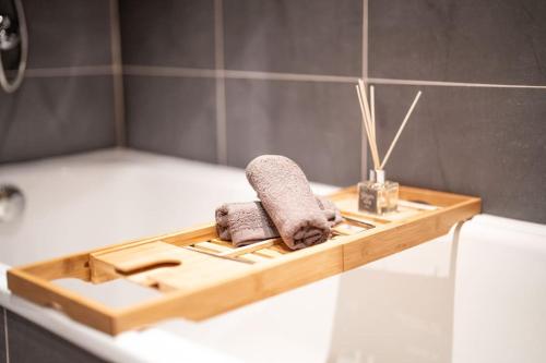 een houten dienblad met twee handdoeken op een bad bij Bansko Best View Apartment in Bansko