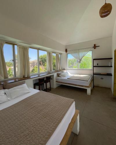 a bedroom with two beds and a large window at Pacifico El Paredon in El Paredón Buena Vista