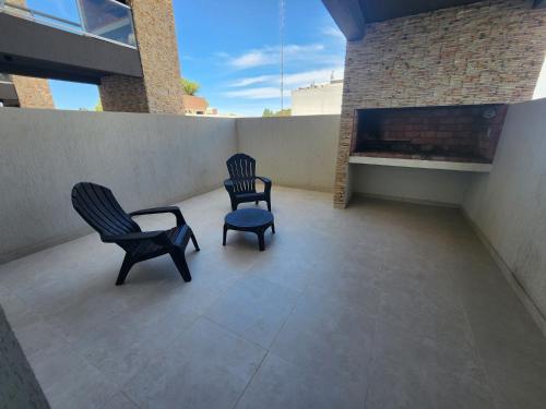two chairs sitting on a patio with a fireplace at PH Patagonia Carrera Aparts in Puerto Madryn