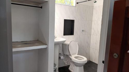 a small bathroom with a toilet and a sink at Cabaña frente a la playa in Tubará
