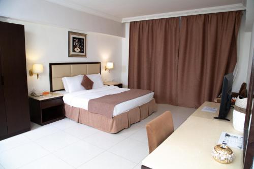 a hotel room with a bed and a television at East hotel in Sowayma
