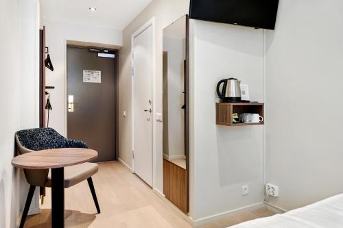 a room with a table and a chair and a closet at Best Western Hotel Karlaplan in Stockholm