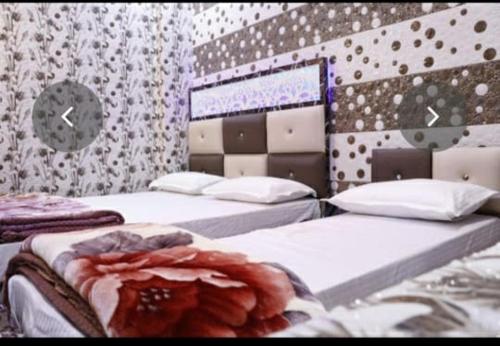 sypialnia z 2 łóżkami i zegarem na ścianie w obiekcie Hotel Pari w mieście Dźalandhar